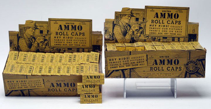 Toy Cap Gun Ammo Display, Lot of Two: Toy Cap Gun Ammo Lithograph Cardboard Country Store Displays produced by United Fireworks Mfg. Each display contains 60 boxes of roll caps. 7" HOA, 10 1/2" L, 4 3/4" D.