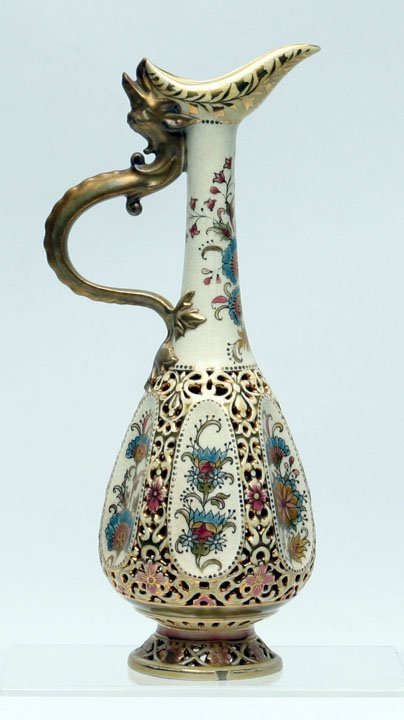 Zsolnay Porcelain Ewer: Zsolnay Porcelain Reticulated Ewer featuring dragon handle. Reticulated lower body & foot, polychrome & gilt decoration. 1878-1898 blue maker's mark on bottom. 11" HOA, 2 3/4" D foot. Carolyn Price Co