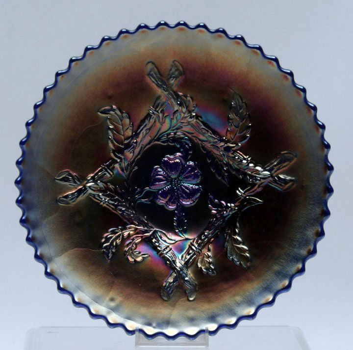 Dugan Carnival Glass Apple Blossom Twigs Plate: Dugan Carnival Glass Apple Blossom Twigs Cobalt Blue Plate with vivid iridescents. Plate features a sawtooth edge & basketweave exterior pattern. Dugan/Diamond Glass Co. 8 3/4" D rim, 1 5/8" H. Caroly