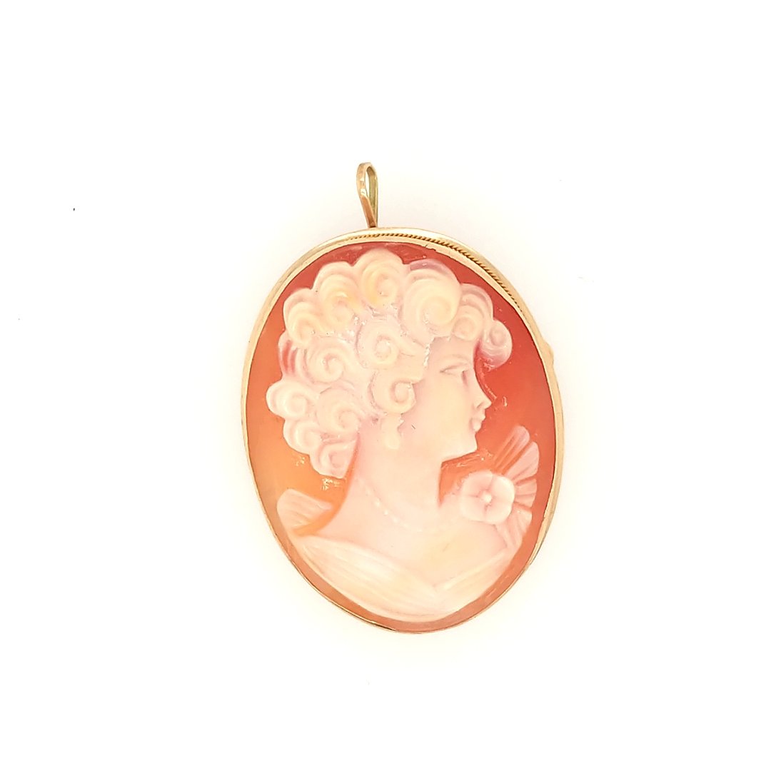 A Cameo: Crafted in 14k yellow gold the brooch depicts a young woman. Size: 1.5" x 1" Weight: 6 grams
