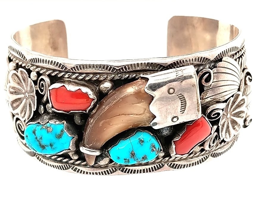A Native American Turquoise Bracelet: Crafted in Sterling silver with turqouise and coral. Stamped Sterling DDC on the inside Size: 2 1/2" x 1 1/2" Weight: 42 dwt