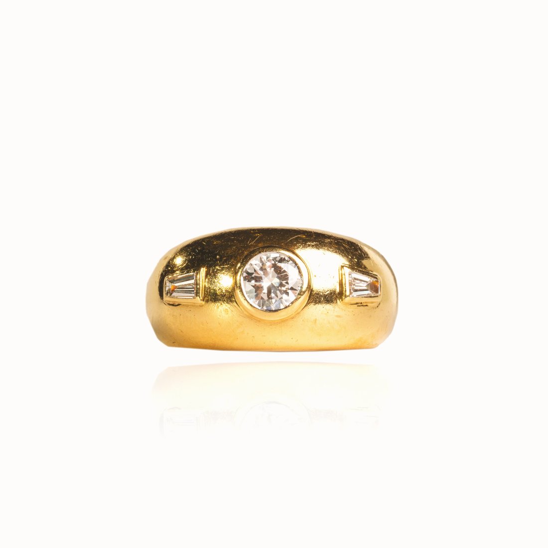 Diamond Fashion Gold Ring: Crafted in 18k yellow gold featuring (1) bezel set round diamond weighing approx. 0.50 ct with a color of F/G and a clarity of VS2-SI1. There are also (2) bezel set tapered diamond baguettes weighing