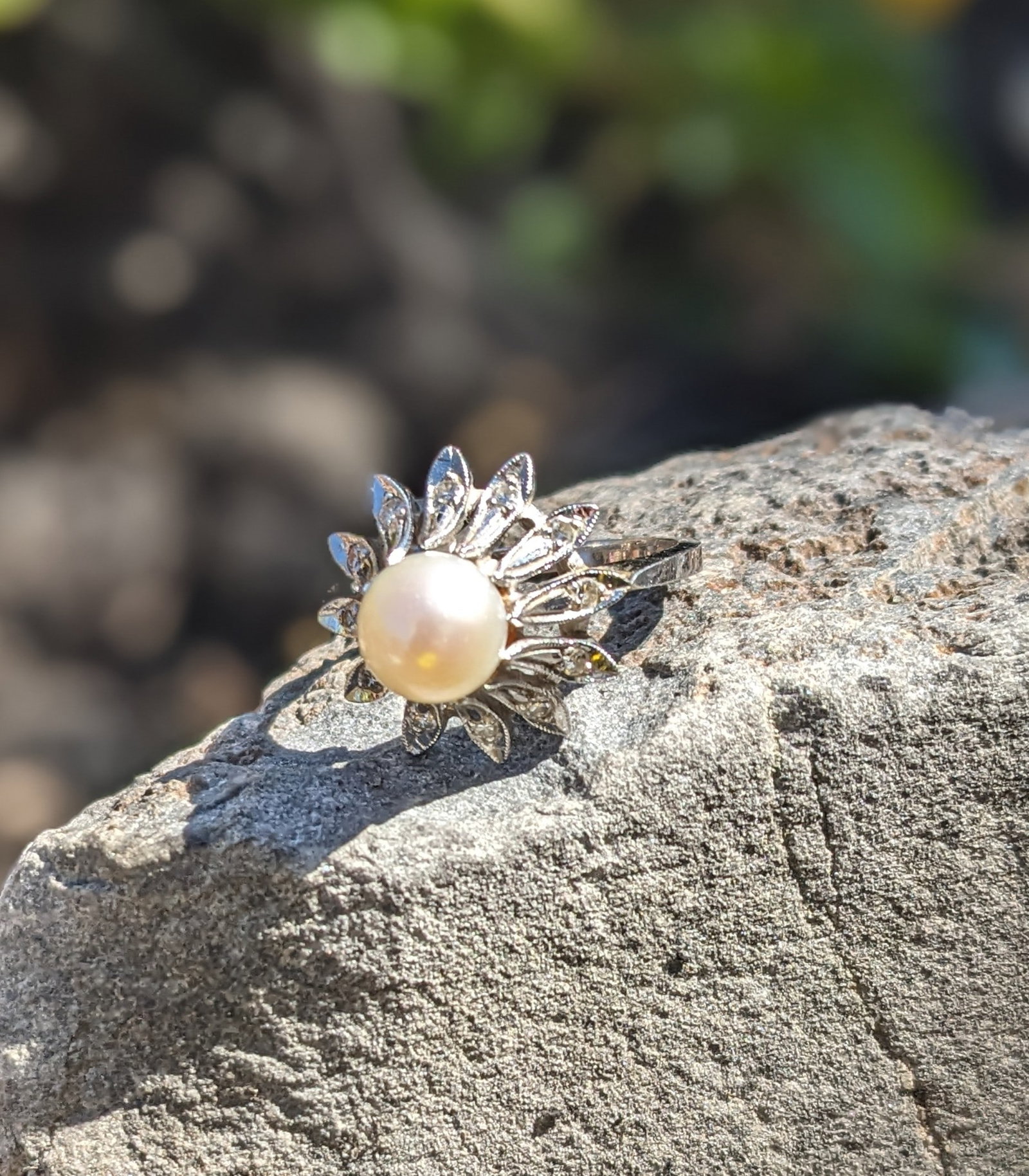 Pearl and Diamond Ring: Crafted in 14k white gold featuring (1) cultured pearl measuring 7.2mm. There are also (12) round diamonds. The ring is a size 5 1/2 and weighs 2.9dwt
