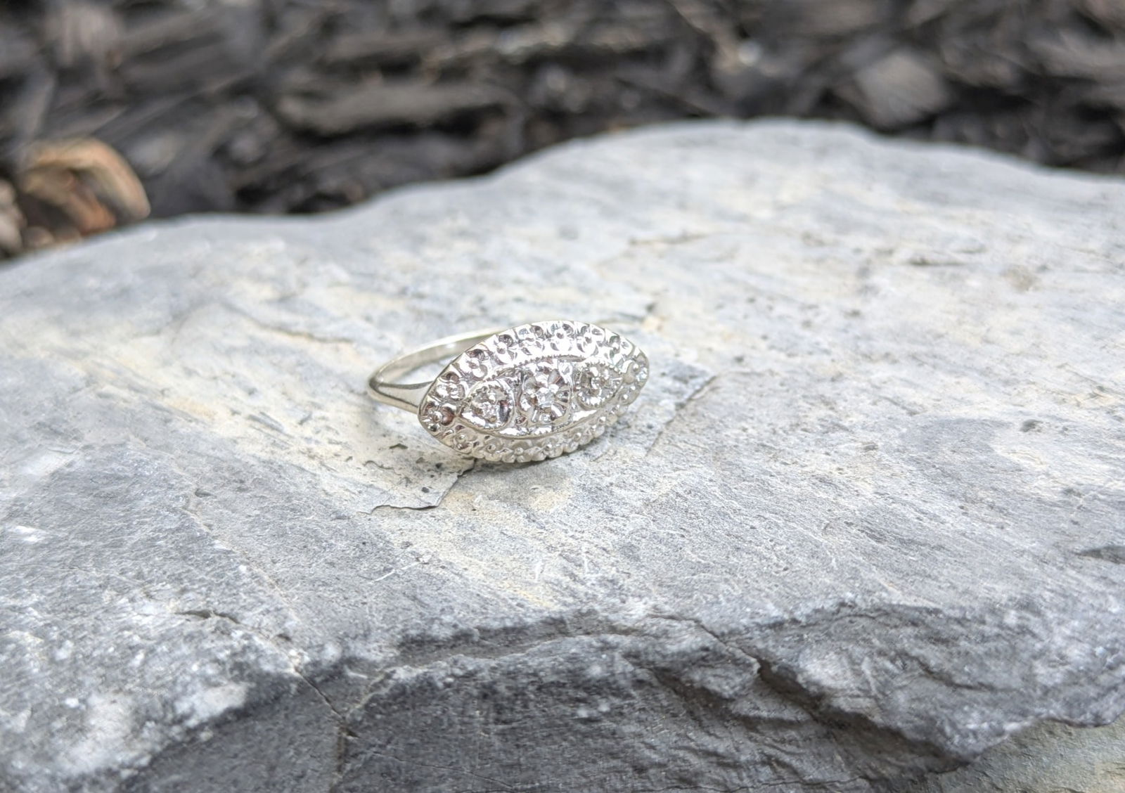 Vintage Diamond Ring: Crafted in 14k white gold featuring (3) round diamonds. The top of the ring measures 3/4in x 1/4in with a ring size of 7 and weighs 1.6dwt