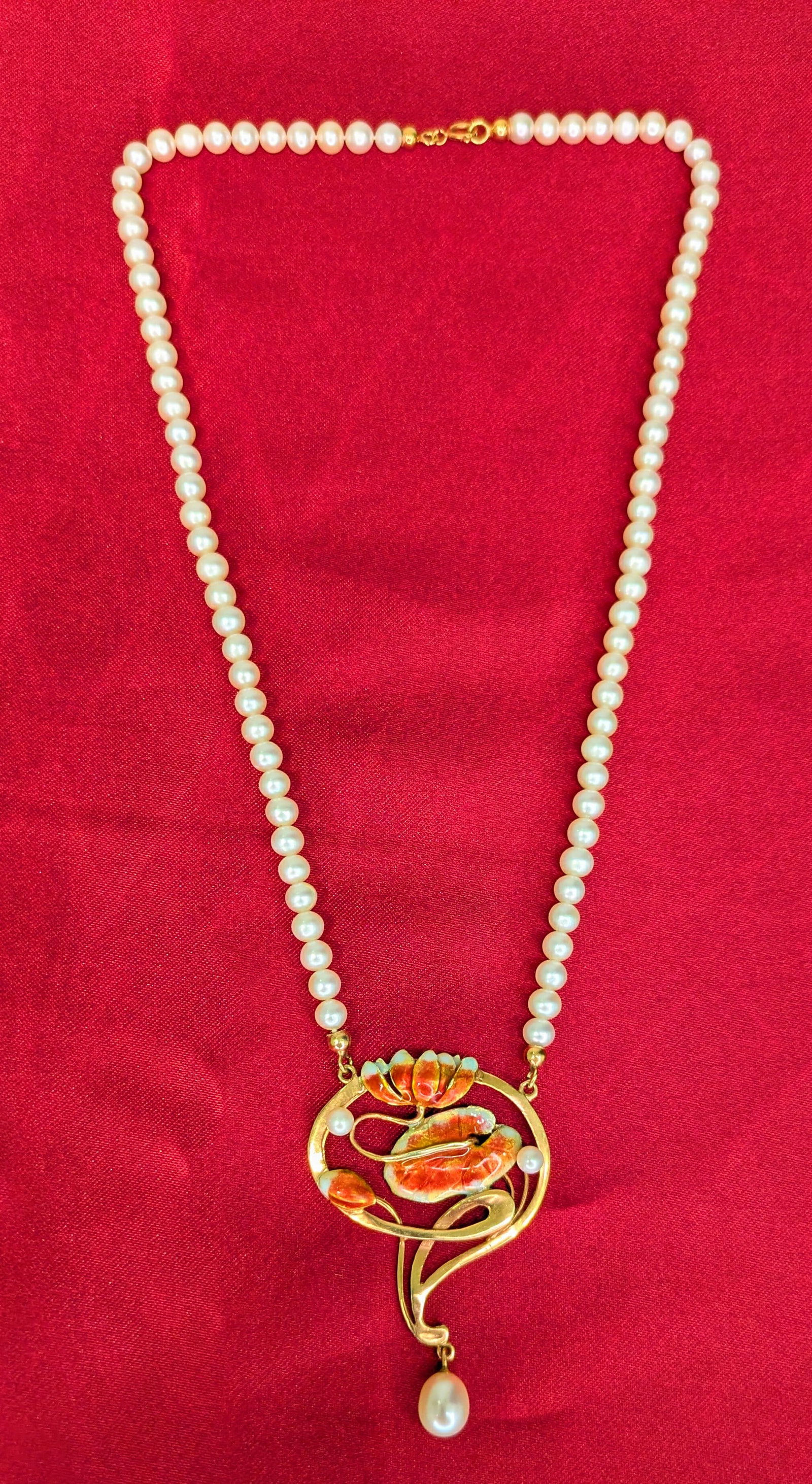 Art Nouveau Pearl Pendant Necklace: Crafted in 14k yellow gold with enamel flowers and pearls. The necklace measures 16in in length with an additional 1 1/2in for the pendant. The total weight is 13.3 dwt.