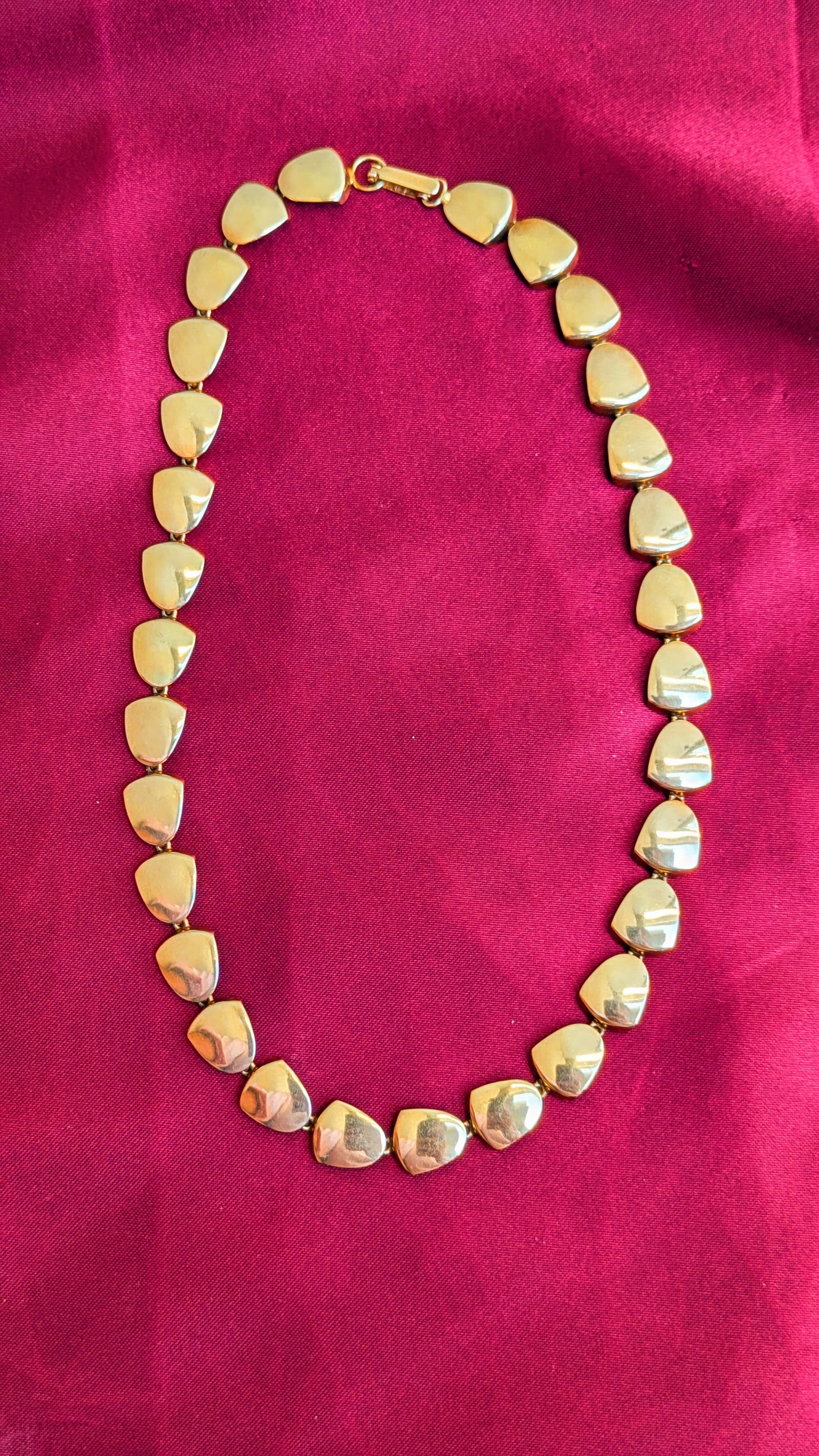 Modernest Gold Necklace: Crafted in 14k yellow gold, the necklace has curved disc shaped links measuring 16in in length and weighs 16.4dwt. It is stamped 14k with a makers mark of M G