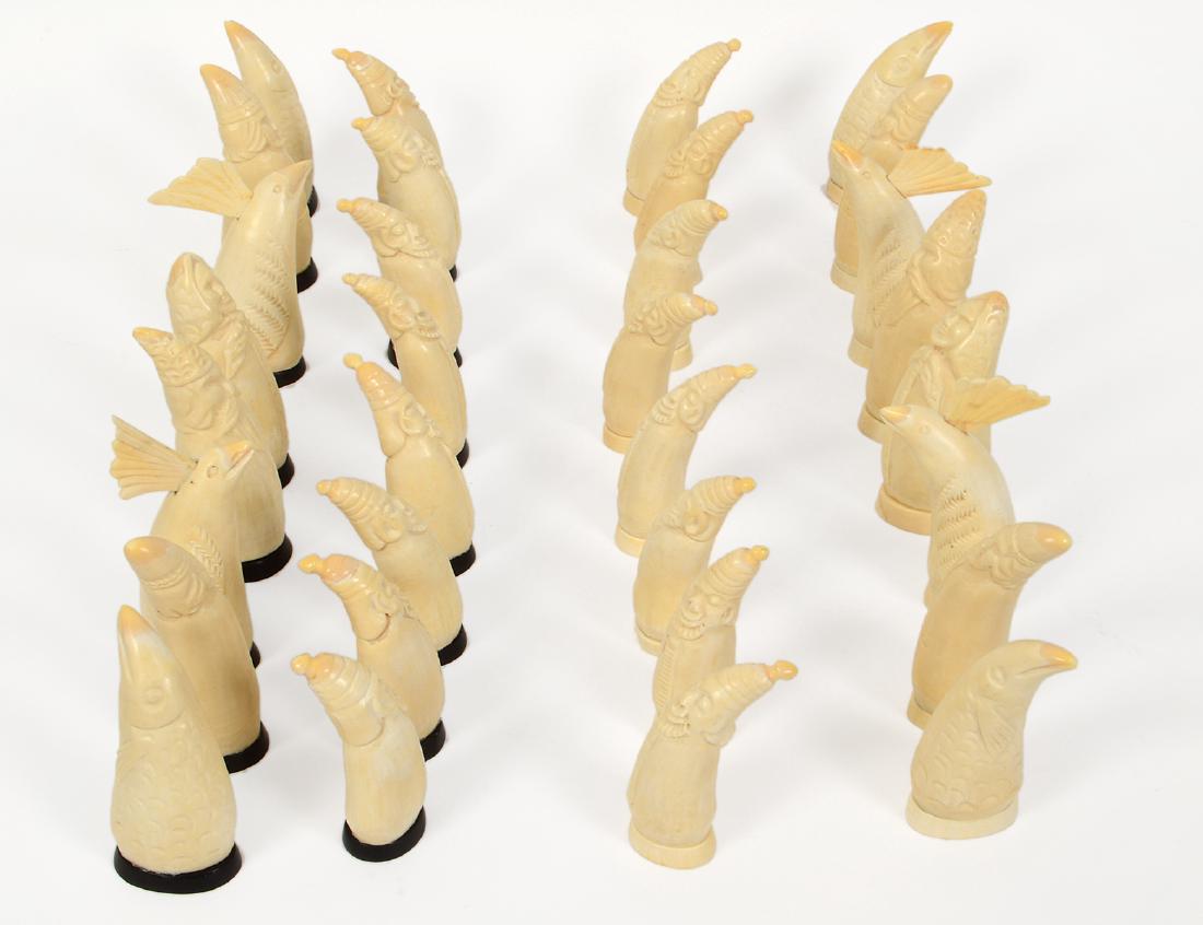 RUSSIAN CARVED WHALE’S TOOTH CHESS SET: First Half of the 20th Century. Carved as land owners, clergy, courtiers, and stylized fish, with black or white oval bases, lacks a board, in a black painted wood box. Height of kings 4 ¾”, pawns