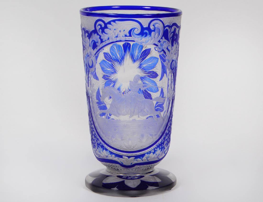FINE BOHEMIAN COBALT CUT TO CLEAR GLASS VASE: Possibly Russian. Circa 1870. In the manner of Franz Paul Zach. Depicting a soldier astride his galloping horse and shooting his rifle, with cobalt and frosted stylized foliate scrolls, the underside 