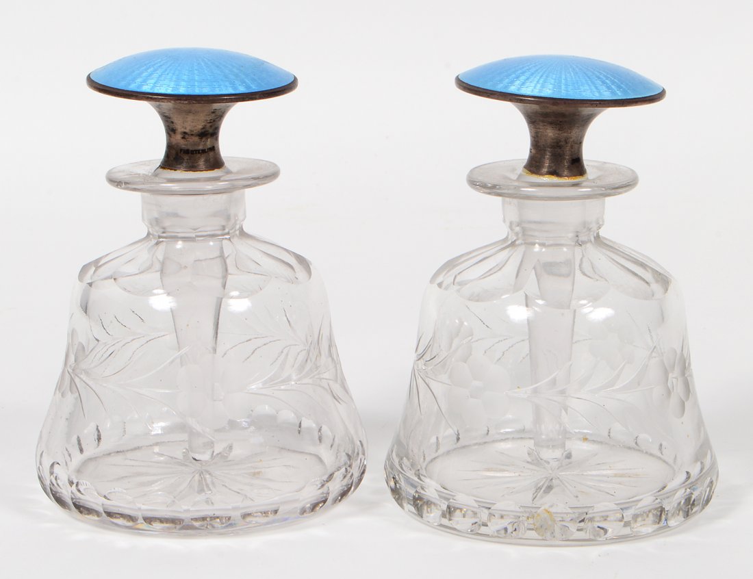 PAIR OF AUSTRIAN ENAMEL AND GLASS SCENT BOTTLES: Circa 1890. Of bell form, with cut stylized geometric foliage, light blue engine-turned enamel caps. Height 5". (Cond: good) (150/250). Provenance: Property from The Estate of Fred J. Emmerich, Harris