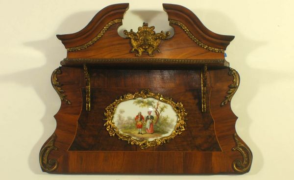 French Louis XV Style Antique Burl and Veneer Hang: French Louis XV Style Antique Burl and Veneer Hanging Wall Shelf with a Hand-Painted Figural Porcelain Gilt-Trimmed Plaque and a Broken Pediment Crest Centered with a Gilt Sun God Medallion, and Accen