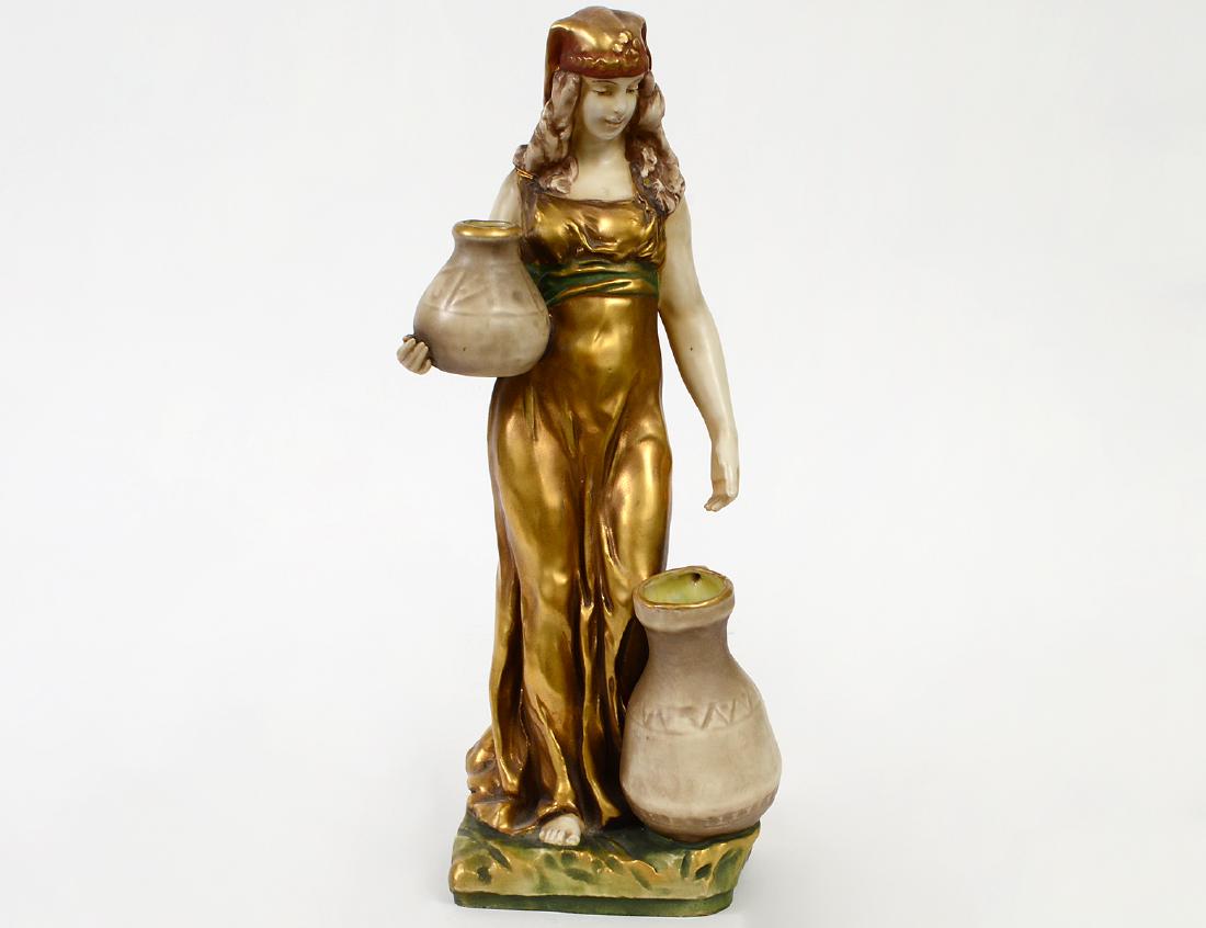 AMPHORA PARCEL GILT CERAMIC FIGURE OF ‘RUTH’: Circa 1900. The underside marked. The figure standing before a well. Height 13". (Cond: good)