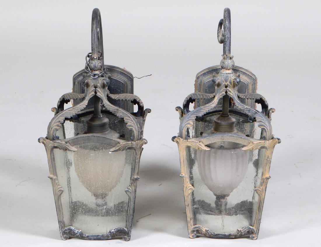 PAIR OF PATINATED METAL & GLASS COACH LANTERNS: En suite with the previous lot, slightly smaller, each with four glazed sides, beneath leaf clasps, a single center pendant light. Height 18". Width 10". (Cond: good)