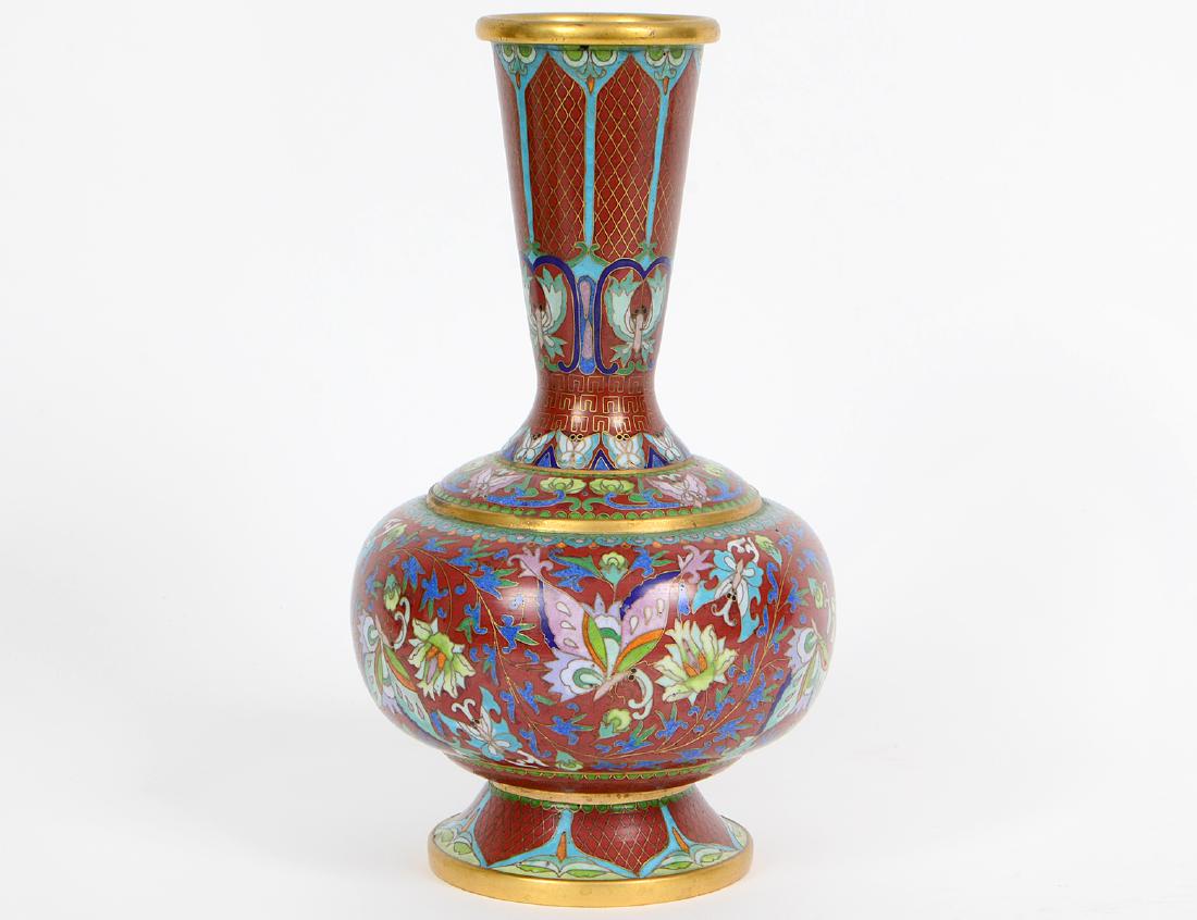 CHINESE ENAMEL ON BRASS CLOISONNE VASE: The flared neck above a compressed spherical body, decorated with butterflies on a brick red ground. Height 9 1/2". Diameter of body 5 3/4". (Cond: good)