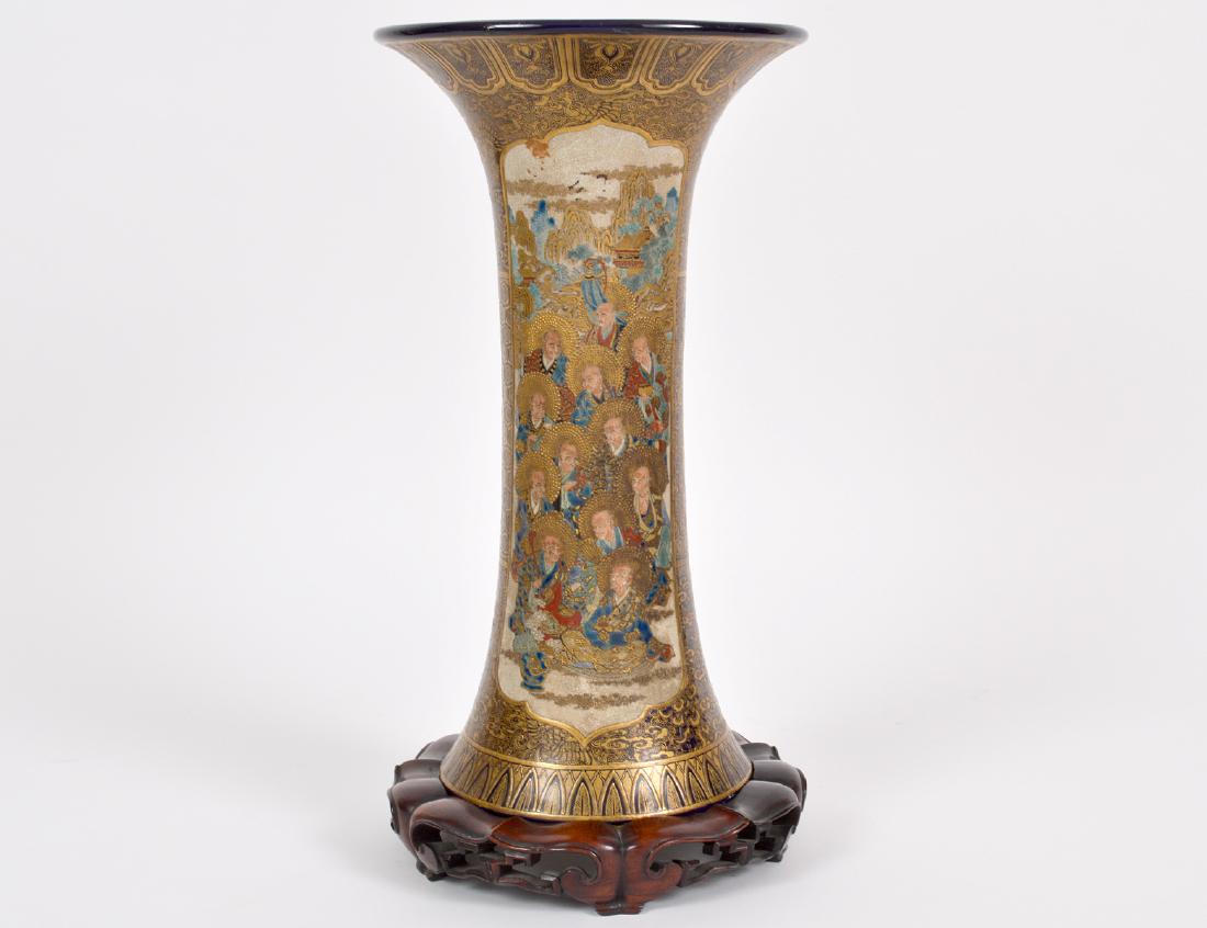 JAPANESE SATSUMA GILT DECORATED EARTHENWARE VASE: Meiji period. The underside with Satsuma seal in blue, gilt character signature and red seal. Reserved with a samurai troop, the reverse with immortals, on a heavily gilt scrolled and cobalt ground. H