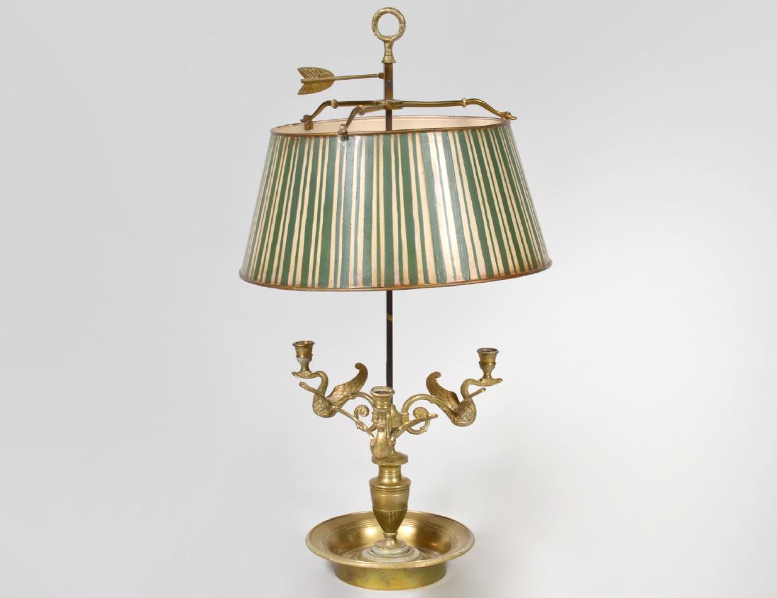 EMPIRE STYLE BRASS THREE-LIGHT BOUILLOTE LAMP: 20th Century. The urn-turned standard with three scrolled arms terminating in swans that support candle nozzles, on a circular dished base. Height 30”. Diameter of shade 16”. (Cond: previo