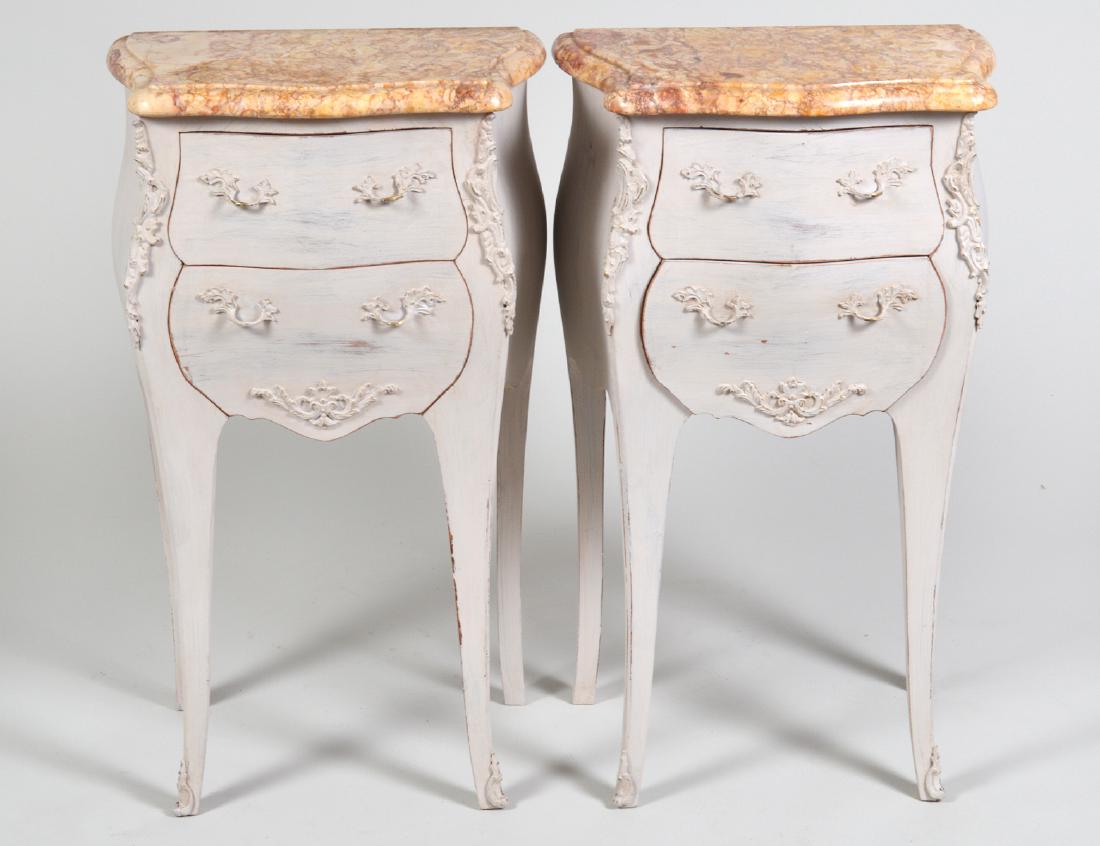 PAIR OF LOUIS XV STY MARBLE TOP PAINTED PETITE COMMODES: Modern. Of serpentine outline, with marble tops, painted bronze mounts, fitted with two drawers on cabriole legs, painted white. Height 28”. Width 26”. Depth 14”. (Cond: painted late