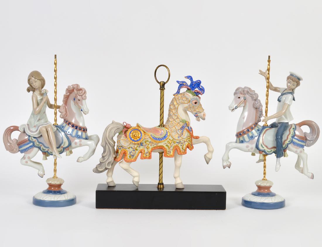 LLADRO BOY/GIRL AT CAROUSEL & CYBIS CAROUSEL HORSE: The Lladro, variously marked, numbers, 1469 and 1470. The Cybis number 196, on a wood base with brass pole. Height of Lladro 16”. Width 10”. Height of Cybis overall 13”. (Cond: Lladr