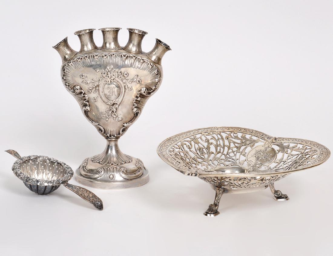 TWO STERLING SILVER TABLE ITEMS AND A TULIP VASE: Late 19th/Early 20th Century. The first, a sterling heart shaped bowl, pierced and chased with Renaissance -style scrolls and foliage, centering a cartouche with a flower-filled basket. The second, a 