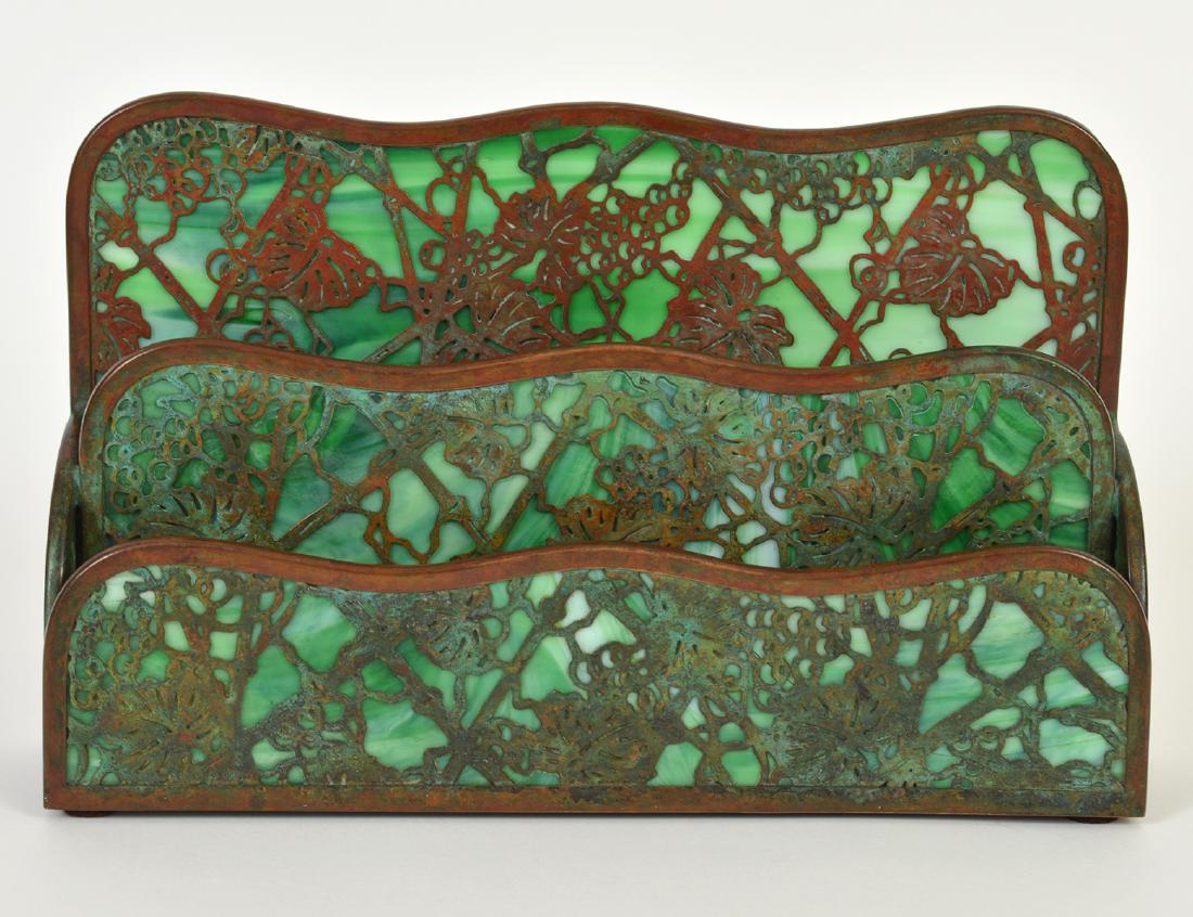 TIFFANY STUDIO COPPER & GLASS LETTER HOLDER: Circa 1900. Stamped Tiffany Studios, New York, 1008. In the grapevine pattern, with green slag glass. Height 7”. Width 10”. (Cond: good)