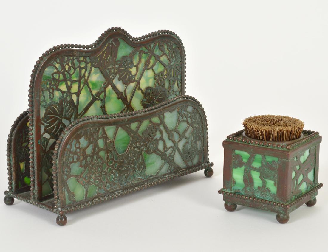 TIFFANY STUDIOS COPPER LETTER HOLDER & INK BRUSH: Circa. The letter holder stamped Tiffany Studios, New York, lacks number, the brush unmarked. In the “Grapevine” pattern, with green slag glass. Height 5 ¾”. Width6 ¼”