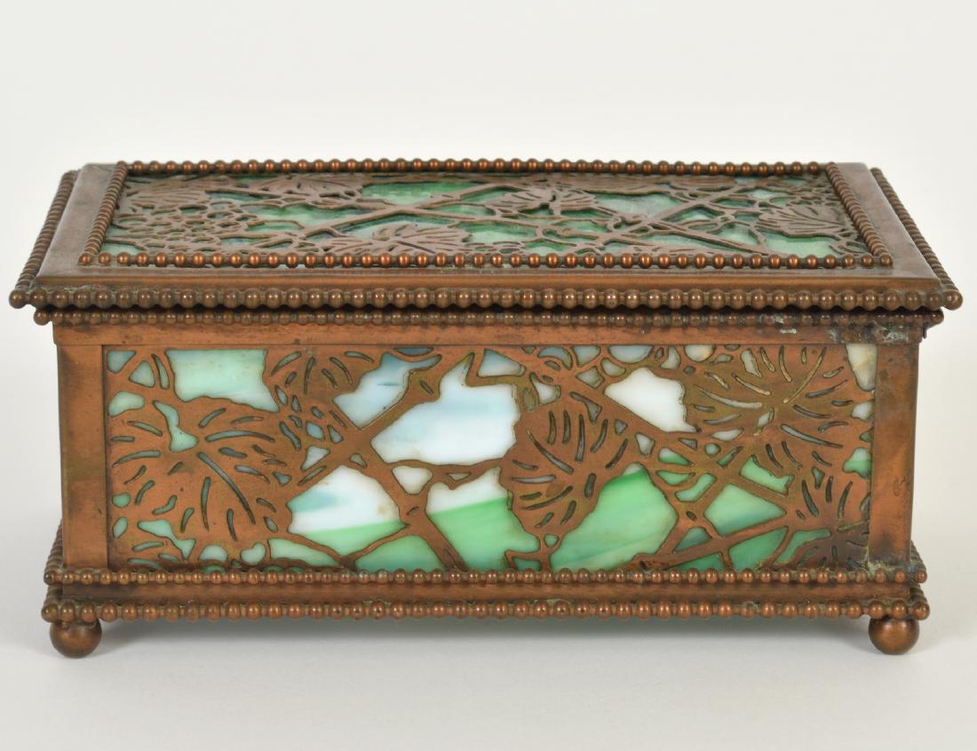 TIFFANY STUDIOS PATINATED COPPER & GLASS BOX: Circa 1900. Stamped Tiffany Studios, New York, numbered 32. Rectangular with green slag glass, the top incised with the initials CHS. Height 3”. Width 7”. (Cond: minor surface blemishes, w