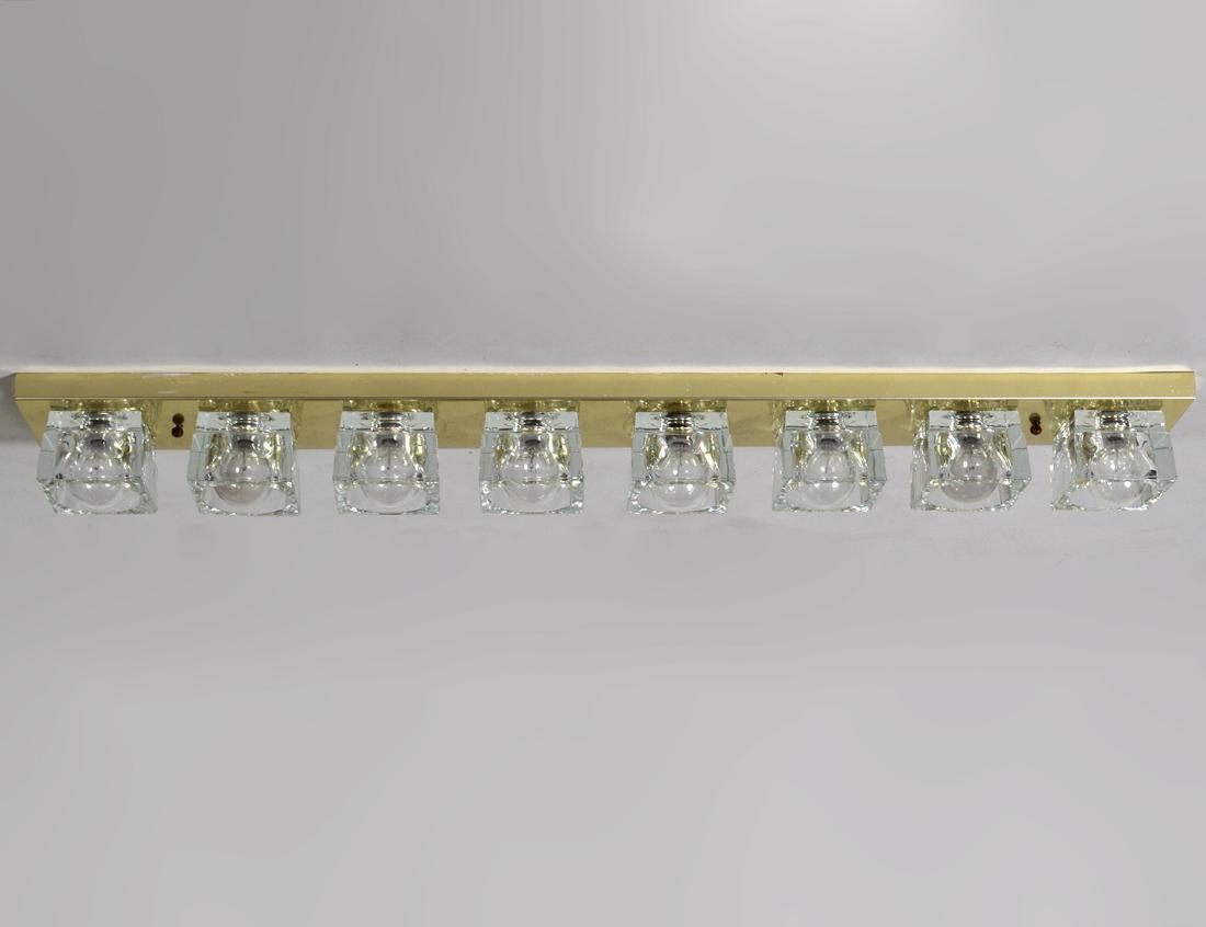 CONTEMPORARY BRASS & GLASS EIGHT LIGHT FIXTURE: The brass mount supporting eight bulbs. Length 36”. (Cond: good)