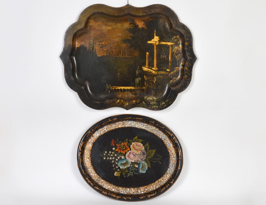 TWO VICTORIAN PAINTED TOLE TRAYS: 19th Century. The first with a wide rim decorated in gold with figures in a landscape with Classical ruins; the second, oval, with a border of mother pearl, centering a floral spray. Width of first 28