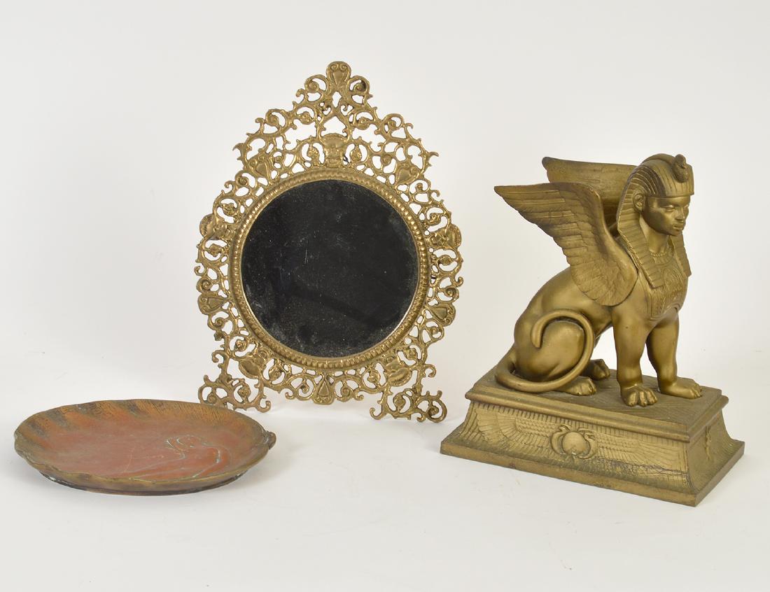 BRONZE SPHINX, AN ART NOUVEAU BRONZE DISH & A MIRROR: Circa 1900. The sphinx seated atop a plinth, the dish cast with a female nude and the mirror cast in a Baroque style. Height of sphinx approx. 12". (Cond: good)