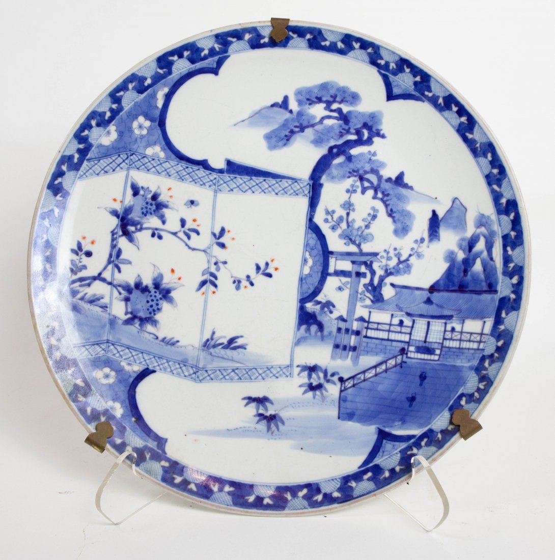 JAPANESE ANTIQUE BLUE AND WHITE PORCELAIN CHARGER: Decorated with Pagoda in a Landscape with Screen with Blossoms and Figures. With double ring circle to bottom. 18 in. diameter. Some fine scratches, no chips.