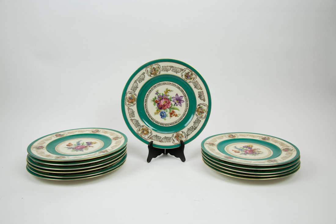 TWELVE BARVARIAN PAINTED PORCELAIN SERVICE PLATES: The undersides marked, and with FBS monogram. Painted with a center floral spray, each rim with a vignette of lovers in a garden, and with a turquoise-green borders, with gilt highlights. Diameter 11 