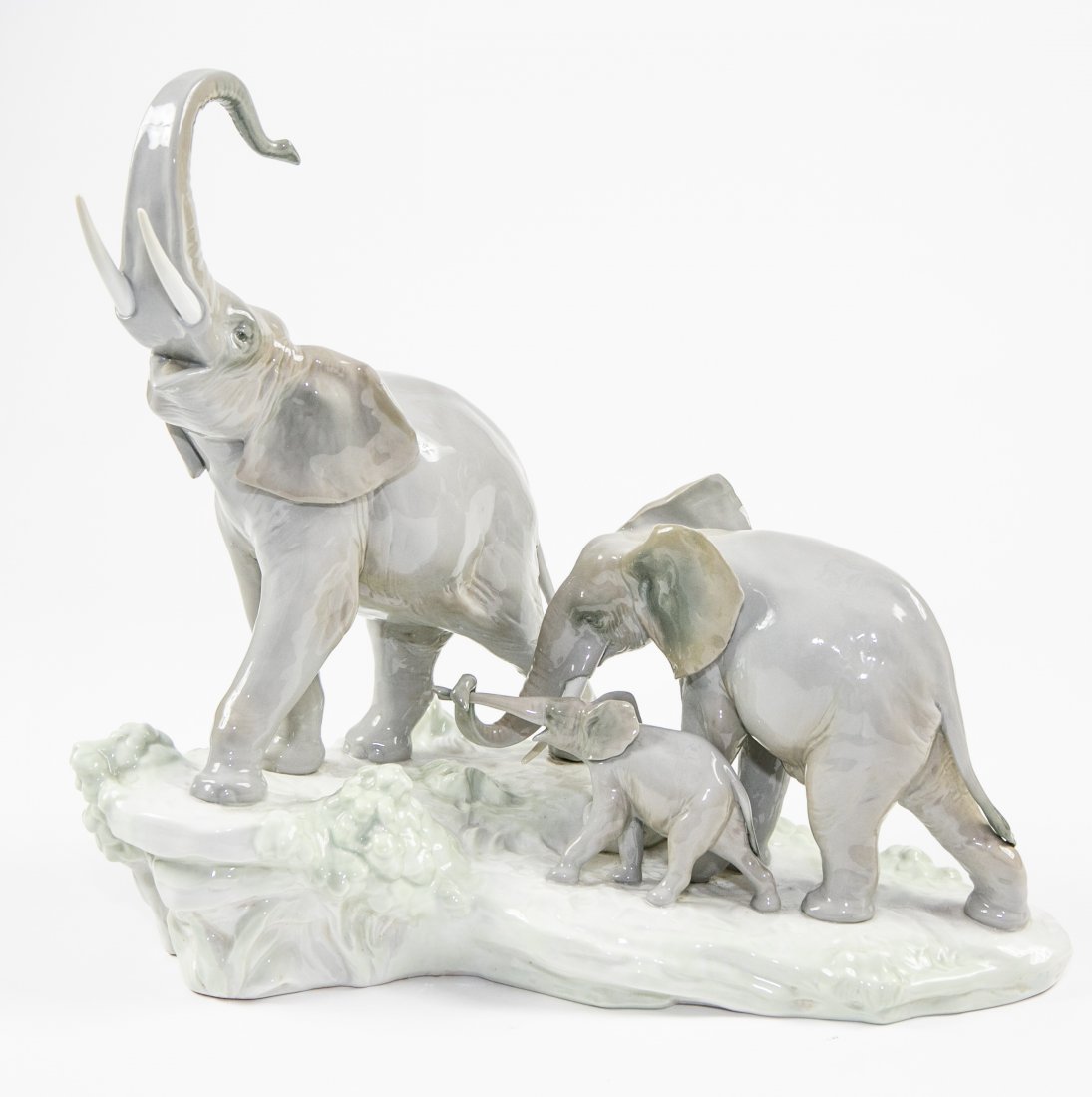LLADRO PORCELAIN ELEPHANT FAMILY: The underside marked. Depicting a bull, matron and her calf, the three poised upon a naturalistic rockwork base. Height 14 in. Width 16 in. (Cond: good)