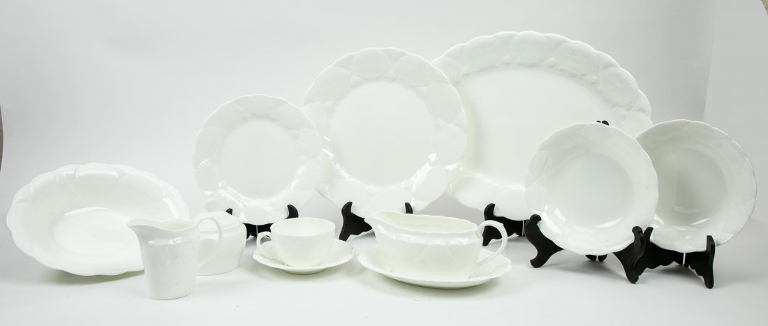 ASSOCIATED ENGLISH MOLDED PORCELAIN DINNER SERVICE: 20th Century. The undersides marked Coalport or Wedgwood. White, the rims molded with shells. Comprising: 12 dinner plates, 12 luncheon plates, ten bowls, an oval platter, an oval serving bowl, a grav