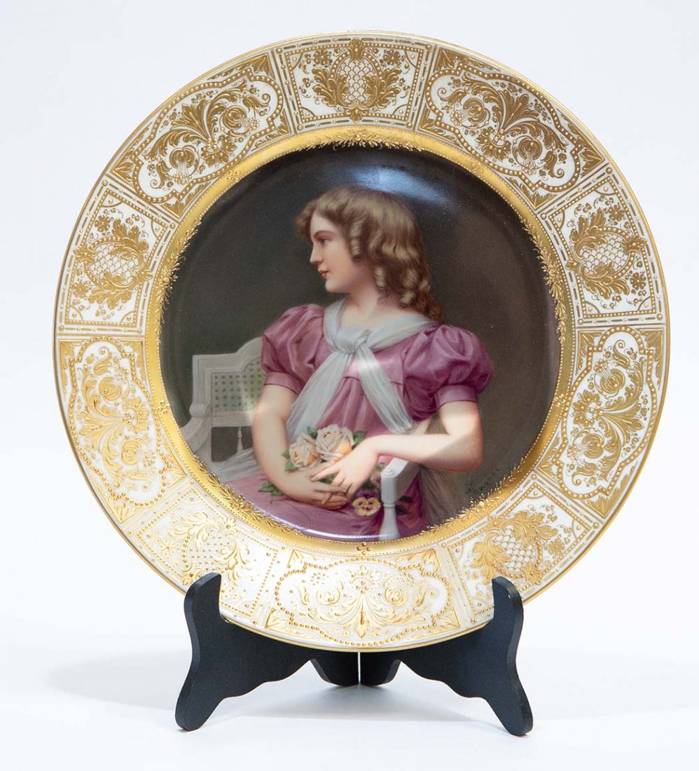 ROYAL VIENNA PAINTED & GILT PORC CABINET PLATE: Circa 1900. The underside with beehive in under glazed blue, with a gilt flower and titled Candeur. The image signed Wagner. Depicting a young girl in a puce dress, seated, and with a bouquet of roses