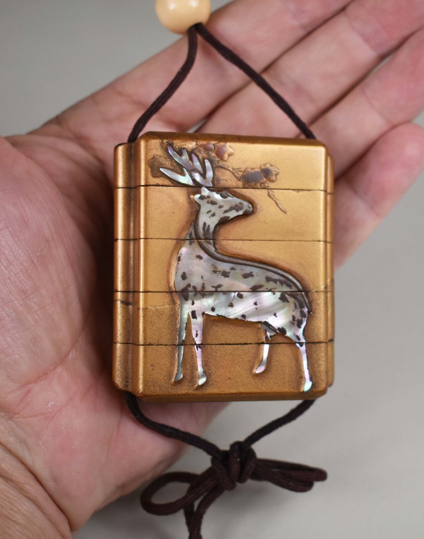 JAPANESE ABALONE MOUNTED GILT LACQUER INRO: Early 20th Century. Segmented and decorated with a buck and doe. Height 2.5 in. (Cond: soiled, otherwise ok)