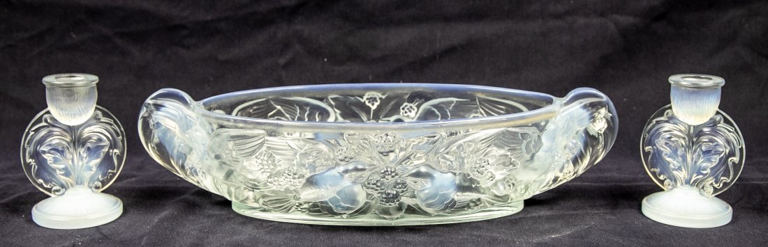 PAIR OF OPALIQUE GLASS CANDLESTICKS AND A BOWL: French, Circa 1930. The candlesticks etched on the underside Jobblings Opalique, molded with stylized leaves, the oval bowl with molded numerals on the underside, molded with birds amidst blossoming f