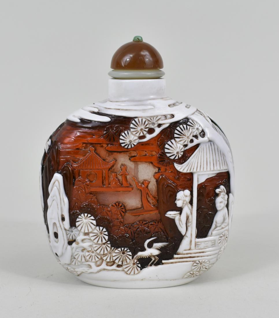 CHINESE TRI-COLOR GLASS MASTER SNUFF BOTTLE: The underside with a five-character signature. The white over brick over red glass cut to clear to depict figures on a terrace in a rock garden with blossoming bushes, with a jade and agate cap. Heigh
