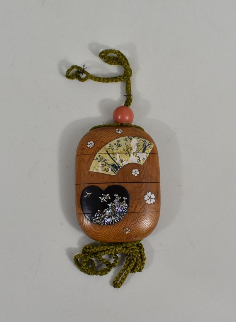 JAPANESE ENAMEL & MOTHER-OF PEARL WOOD INRO: Meiji Period. Decorated with painted fan and heart shaped reserves, and inlaid with mother-of-pearl flower heads. Height 3.5 in. (Cond: good)