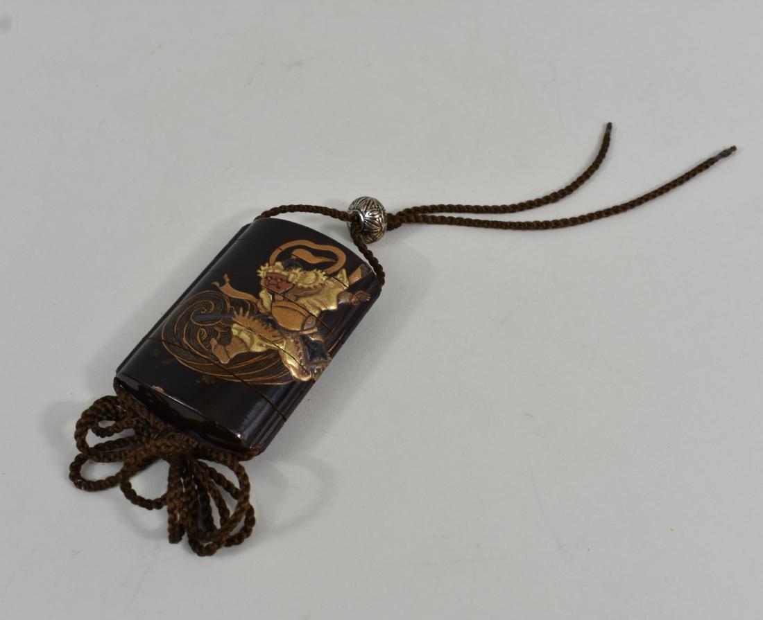 JAPANESE GILT AND BLACK LACQUER INRO: Meiji Period. Decorated with a gilt Samurai and an Oni on a black lacquer ground. Height 3 in. (Cond: numerous small chips to edges of lower section) )