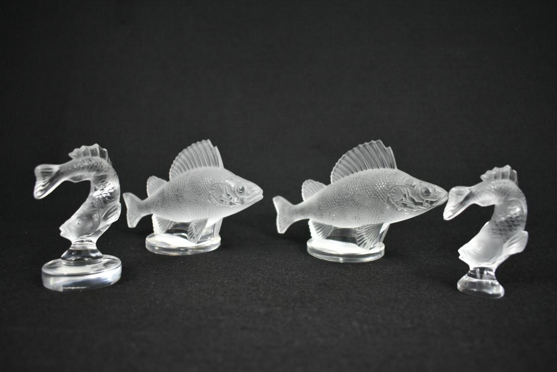 FOUR LALIQUE COLORLESS GLASS FISH: Modern. Signed in script Lalique France. Depicting two pairs of partially frosted fish, on circular bases. Heights 3 in., 4 in. Widths 6 in., 2 in. (Cond: all good)