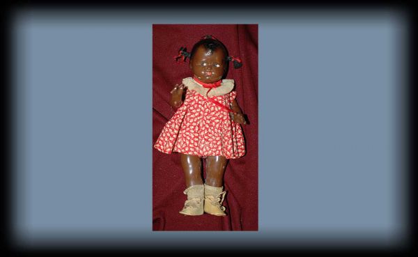 Effanbee 1950s Composition Black Girl Doll: Effanbee 1950s Composition Black Girl Doll with Original Clothes. The unhappy child with molded Effanbee mark at back shoulders. Height: 12 1/2 inches. Width: 5 1/4 inches at hands. Good condition wit