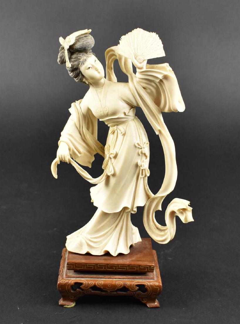 CHINESE REPUBLIC PERIOD CARVED BEAUTY: 1900-1920. The elegant figure in a dance pose, with long robes, black stained hair and with a displayed fan, on a wood stand. Height 8 in., overall 9.75 in. (Cond: good)
