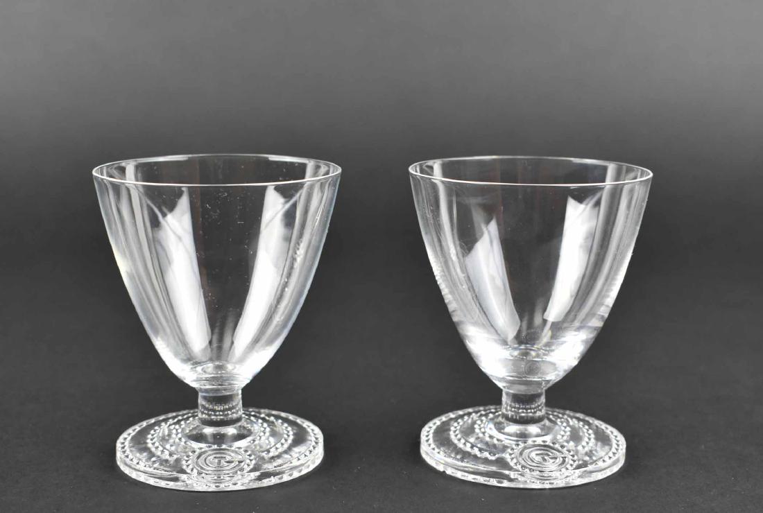 RARE PR. LALIQUE WINE GLASSES FROM S.S. NORMANDIE: Circa 1934. Inscribed signature R Lalique France. The tapered bell shaped bowls on a short stem above a circular foot with a beaded border centering the initials CTG, for the ship’s owner, the Compa