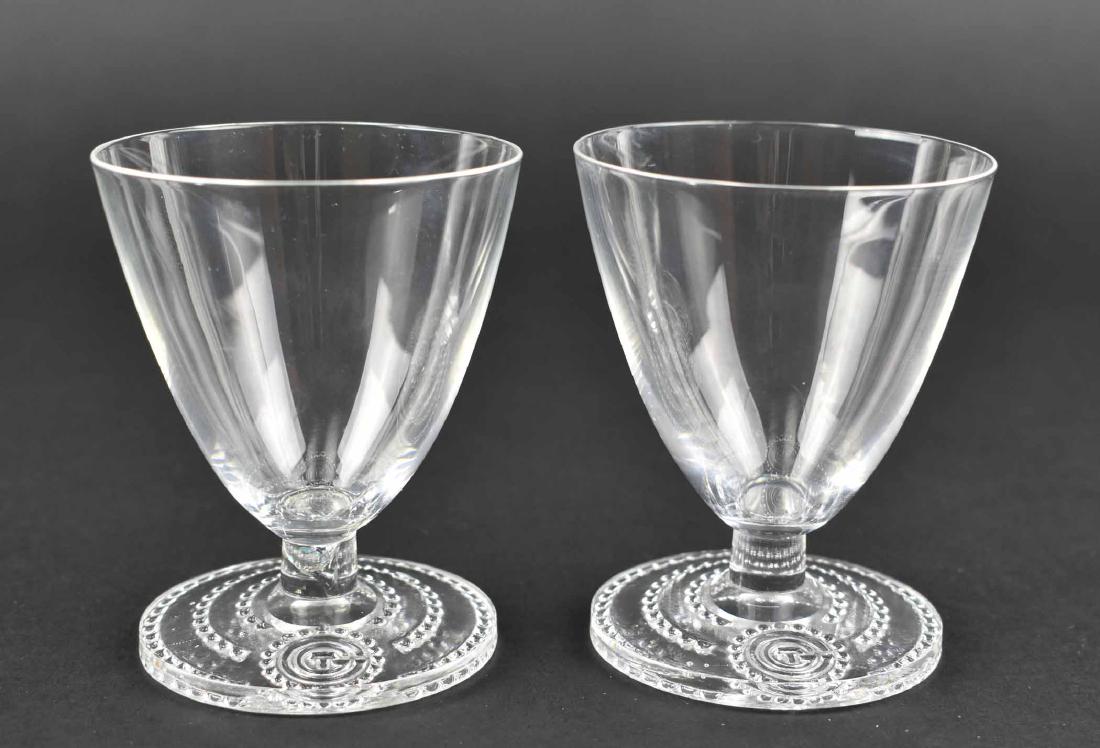 RARE PR. LALIQUE WINE GLASSES FROM S.S. NORMANDIE: Circa 1934. Inscribed signature R Lalique France. The tapered bell shaped bowls on a short stem above a circular foot with a beaded border centering the initials CTG, for the ship’s owner, the Compa