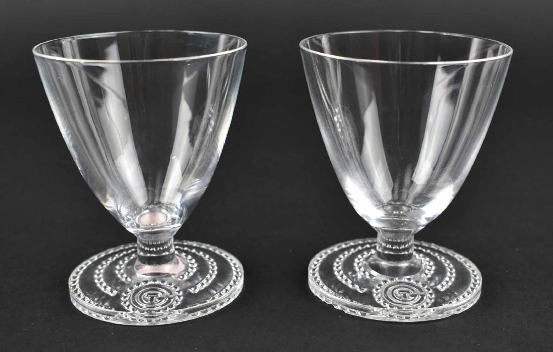 RARE PR. LALIQUE WINE GLASSES FROM S.S. NORMANDIE: Circa 1934. Inscribed signature R Lalique France. The tapered bell shaped bowls on a short stem above a circular foot with a beaded border centering the initials CTG, for the ship’s owner, the Compa