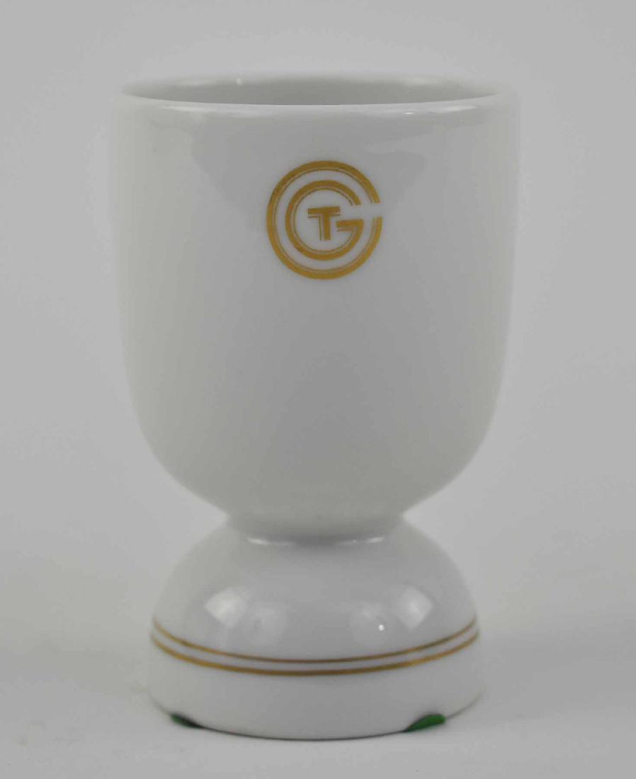 LIMOGES S.S. NORMANDIE PORCELAIN EGG CUP: 1931-1934. Designed by Suzanne Lalique-Haviland, the daughter of Rene Lalique, for the dining room of the Grand Luxe Suites. The underside marked SDA/Limoges/France. The tapered cylindrical cup with a