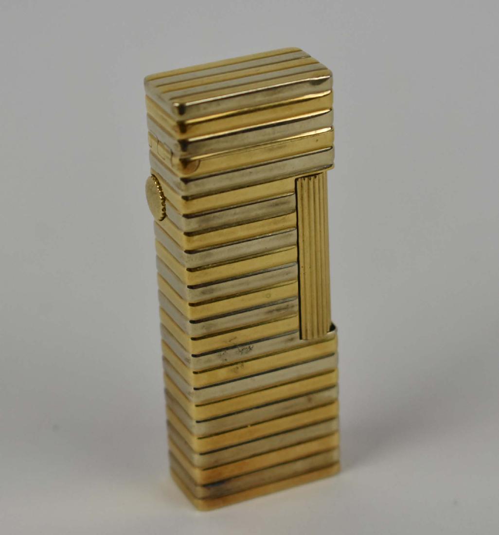 DUNHILL VINTAGE GOLD CASED FLINT LIGHTER: Marked Dunhill twice, numbered 2422, Swiss Made, 18k outer jacket. The case with alternating bands of white and yellow gold, with a wheel for adjusting the flame. (Cond: good)