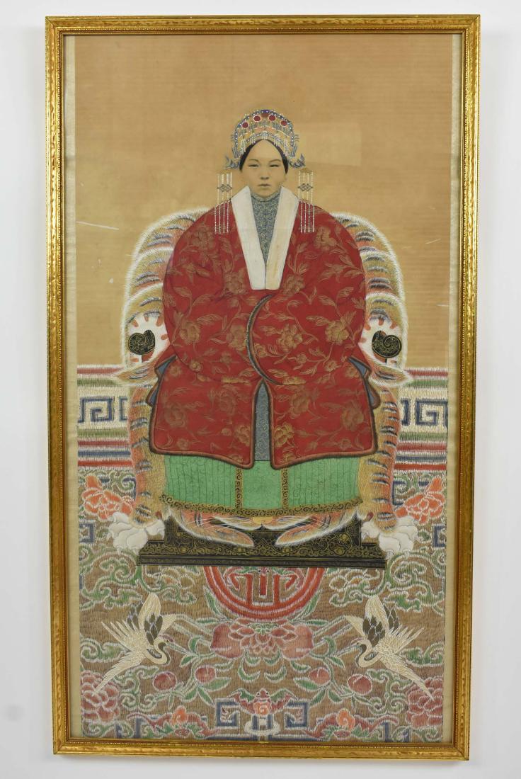 CHINESE ANCESTRAL PORTRAIT OF A PRINCESS: Probably 19th Century. Painted on silk, the young woman in a red robe decorated with gilt foliage and with a jeweled headdress, depicted seated on a black lacquer throne beneath a rug with two cranes 