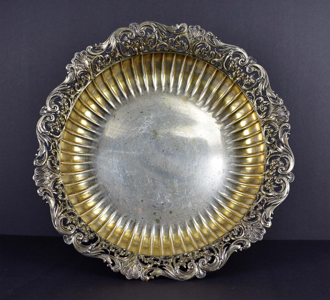 AMERICAN STERLING SILVER BOWL: 1891. Mermod & Jaccard Co. The underside also incised Jacob & Elizabeth Feichert To Their Daughter Julia Lemp Christmas 1889. The pierced foliate and scroll rim above a fluted basin on four pierced sc