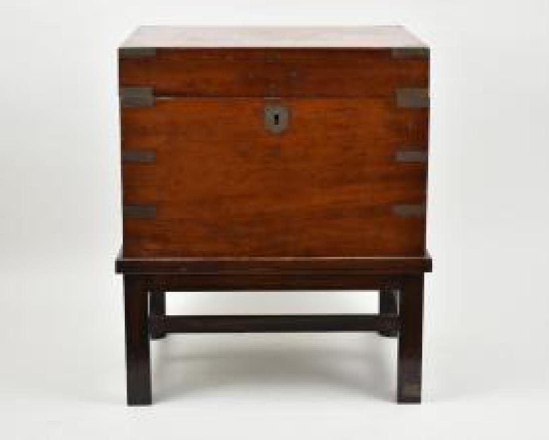 EARLY VICTORIAN MAHOGANY CAMPAGNE CELLERETTE: 19th Century. Rectangular, with brass fittings, on a later stand. Overall height 20.5 in. Width 16.5 in. Depth 12.5 in. (Cond: reasonably good, old surface scratches, later stand)