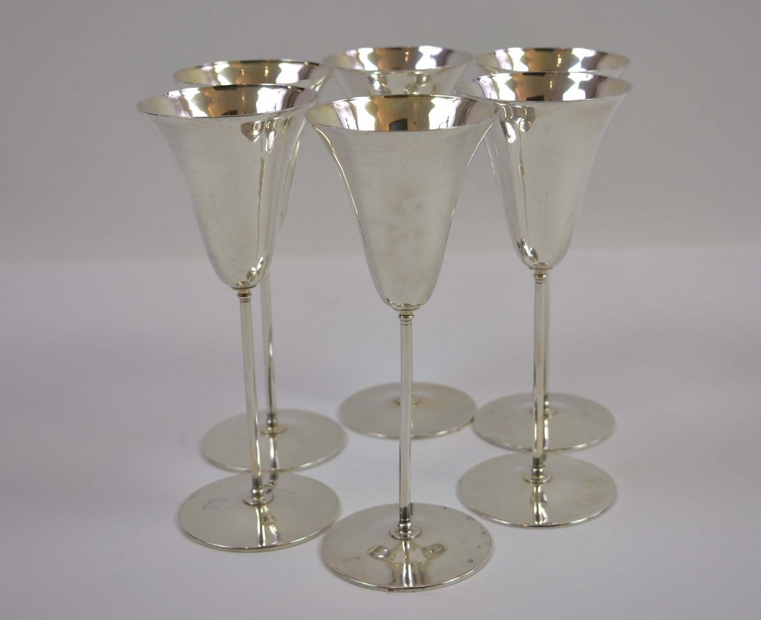 SET OF SIX TIFFANY STERLING SILVER WINE GLASSES: The underside marked, numbered, also inscribed N.Y.S.E.G.A. 1963. Of tulip shape on slender stems with a circular foot. Height 7.75 in. Diameter 3 in. Weighs 36.6 oz. (Cond: good)